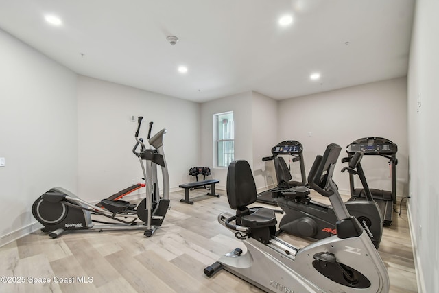 exercise room featuring light wood finished floors, recessed lighting, and baseboards