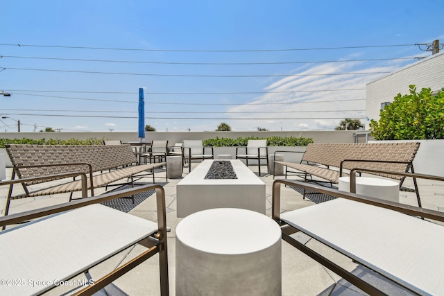 view of patio with an outdoor living space with a fire pit and outdoor dining area