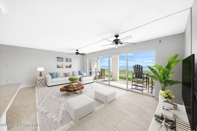 2203 Atlantic St Unit 715, Melbourne Beach, FL 32951 - living area with stone tile floors, a ceiling fan, and baseboards