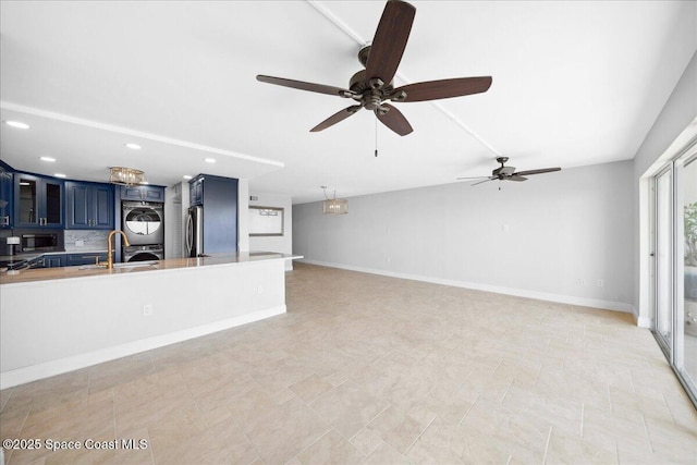 2203 Atlantic St Unit 715, Melbourne Beach, FL 32951 - unfurnished living room with stacked washing machine and dryer, recessed lighting, ceiling fan, a sink, and baseboards