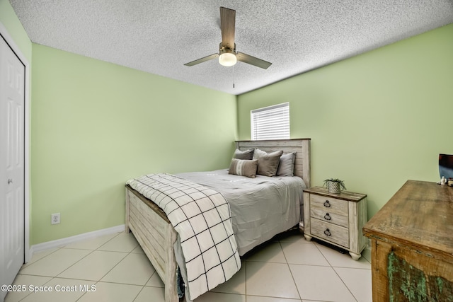 644 Sheridan Woods Dr, Melbourne, FL 32904 - bedroom with light tile patterned floors, a textured ceiling, a closet, a ceiling fan, and baseboards