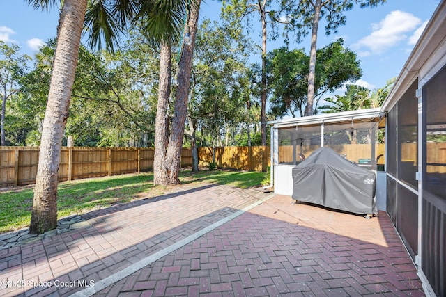 644 Sheridan Woods Dr, Melbourne, FL 32904 - view of patio featuring a sunroom, a fenced backyard, and area for grilling