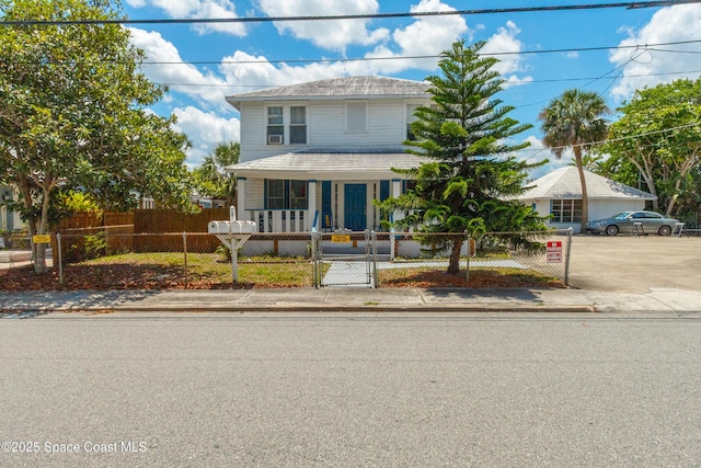 137 Peachtree St, Cocoa, FL 32922 - american foursquare style home with a porch, a fenced front yard, and a gate