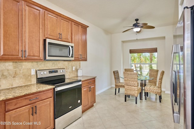 6227 Thames Pl, Vero Beach, FL 32966 - kitchen featuring stainless steel appliances, tasteful backsplash, brown cabinets, baseboards, and a ceiling fan