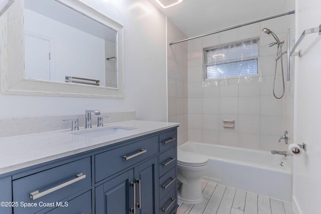 bathroom featuring toilet, vanity, tub / shower combination, and wood finished floors