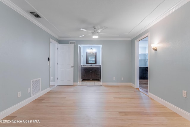 unfurnished living room featuring ornamental molding, a ceiling fan, light wood-type flooring, baseboards, and a sink