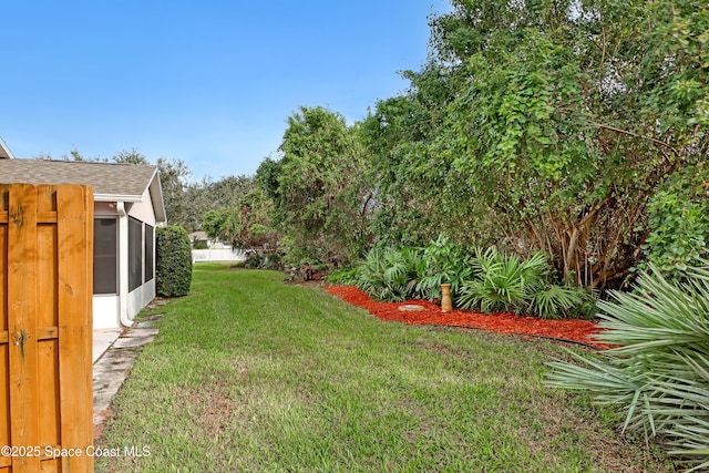 view of grassy yard featuring a sunroom