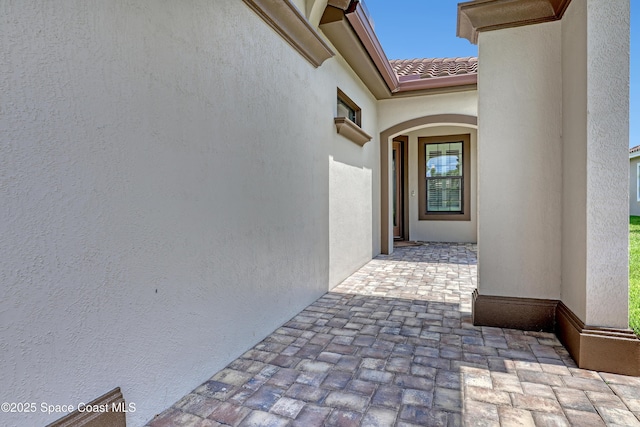 2922 Addison Dr, Melbourne, FL 32940 - view of exterior entry with stucco siding, a tile roof, and a patio