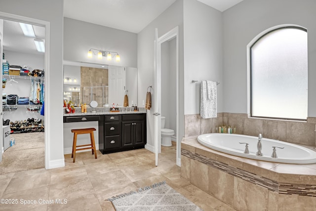2922 Addison Dr, Melbourne, FL 32940 - bathroom with vanity, a bath, toilet, a shower stall, and a spacious closet