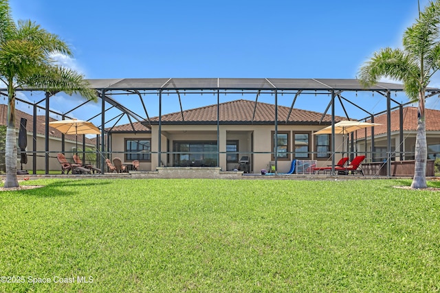 2922 Addison Dr, Melbourne, FL 32940 - back of property featuring stucco siding, glass enclosure, a yard, and a tile roof