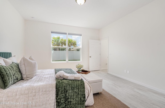 bedroom with wood finished floors and baseboards