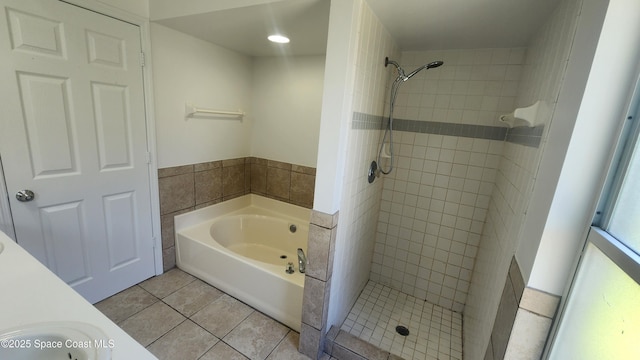 bathroom featuring a bath, a shower stall, and tile patterned flooring
