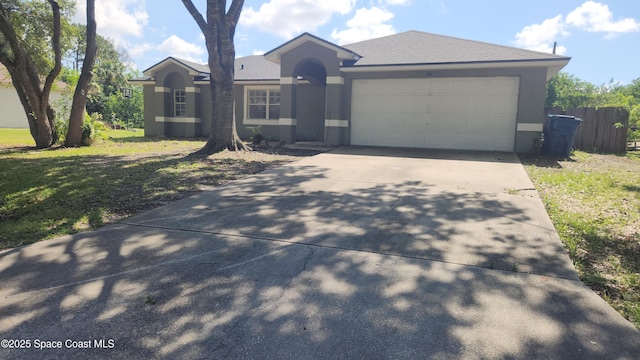 ranch-style home with concrete driveway, stucco siding, and an attached garage