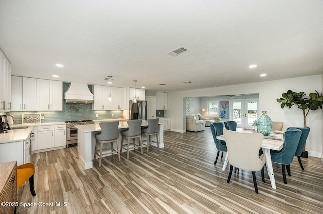 407 Sandpiper Dr, Satellite Beach, FL 32937 - dining area featuring light wood finished floors, recessed lighting, french doors, and baseboards