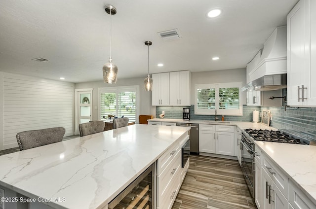 407 Sandpiper Dr, Satellite Beach, FL 32937 - kitchen featuring appliances with stainless steel finishes, beverage cooler, decorative backsplash, white cabinetry, and recessed lighting