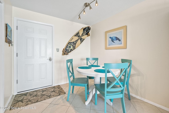 2625 S Atlantic Ave Unit 17, Cocoa Beach, FL 32931 - dining room with tile patterned floors, baseboards, and rail lighting