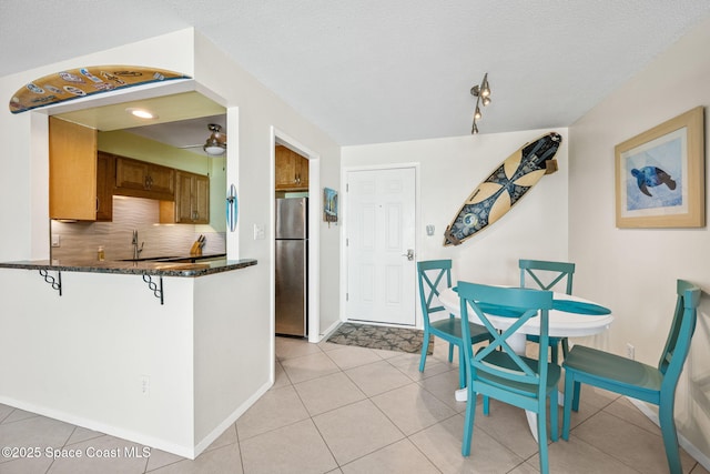 2625 S Atlantic Ave Unit 17, Cocoa Beach, FL 32931 - dining space with ceiling fan, baseboards, light tile patterned floors, and a textured ceiling