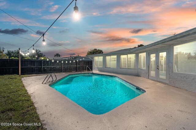 921 S Orlando Ave, Cocoa Beach, FL 32931 - pool at dusk with french doors, a patio, and fence