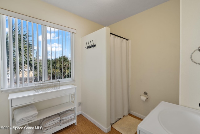921 S Orlando Ave, Cocoa Beach, FL 32931 - bathroom featuring wood finished floors, baseboards, a sink, and curtained shower