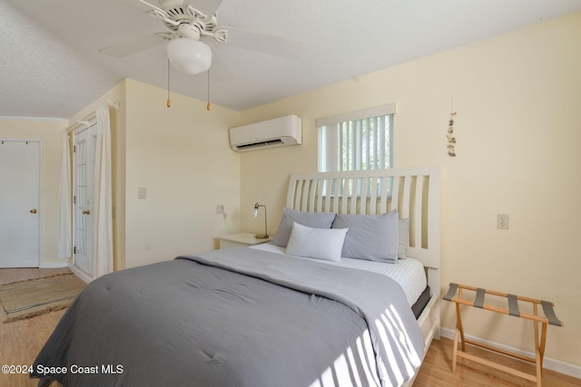 921 S Orlando Ave, Cocoa Beach, FL 32931 - bedroom featuring an AC wall unit, wood finished floors, ceiling fan, and baseboards