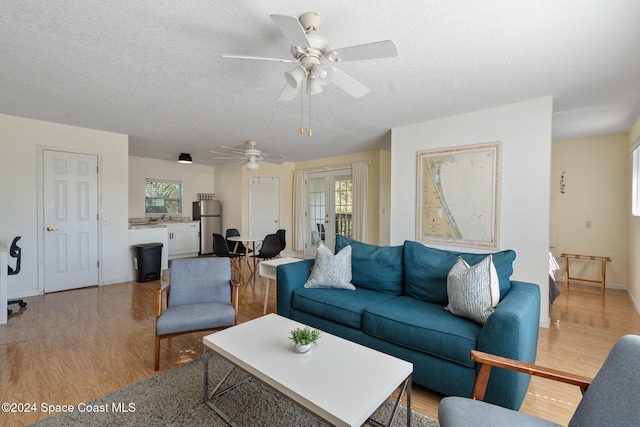 921 S Orlando Ave, Cocoa Beach, FL 32931 - living area with light wood-style floors, healthy amount of natural light, a textured ceiling, and a ceiling fan