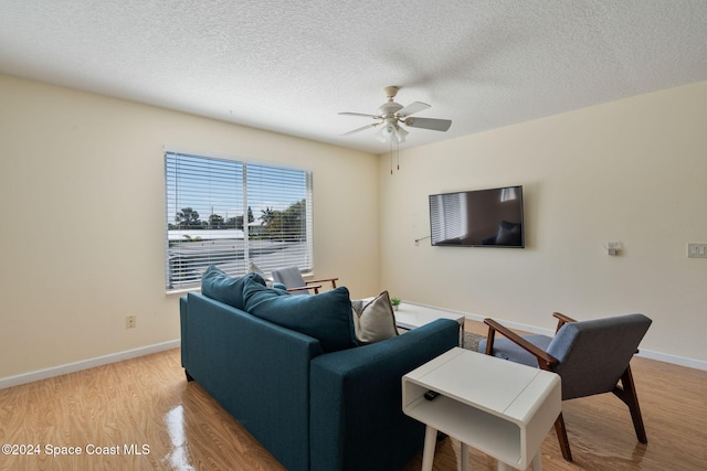 921 S Orlando Ave, Cocoa Beach, FL 32931 - living area featuring light wood-style flooring, a ceiling fan, baseboards, and a textured ceiling