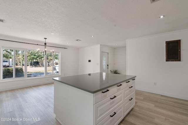 921 S Orlando Ave, Cocoa Beach, FL 32931 - kitchen with a textured ceiling, light wood-type flooring, dark countertops, baseboards, and a chandelier
