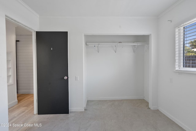 921 S Orlando Ave, Cocoa Beach, FL 32931 - unfurnished bedroom featuring ornamental molding, a closet, and baseboards