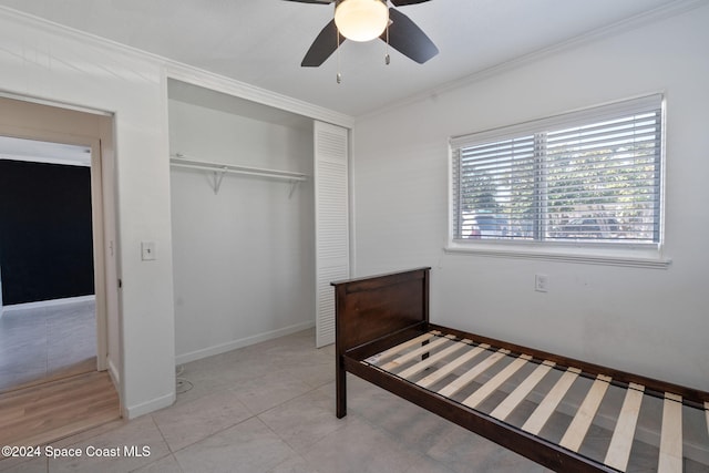 921 S Orlando Ave, Cocoa Beach, FL 32931 - unfurnished bedroom featuring ornamental molding, a closet, a ceiling fan, baseboards, and light tile patterned floors