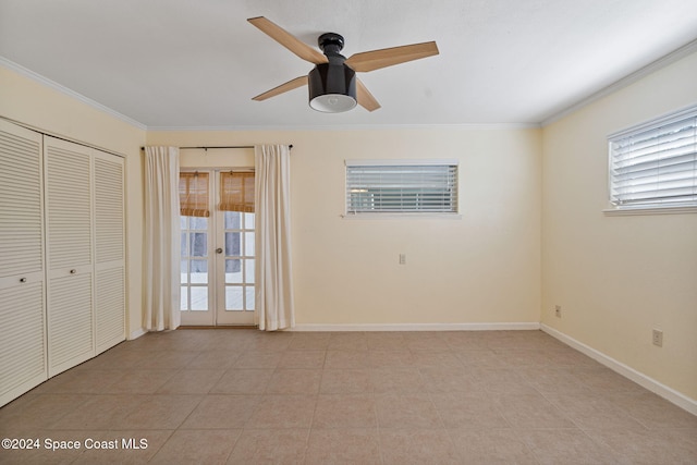 921 S Orlando Ave, Cocoa Beach, FL 32931 - unfurnished bedroom with multiple windows, crown molding, baseboards, a ceiling fan, and a closet