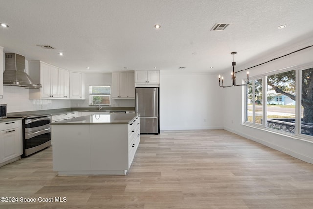 921 S Orlando Ave, Cocoa Beach, FL 32931 - kitchen with wall chimney exhaust hood, appliances with stainless steel finishes, a chandelier, a sink, and a kitchen island