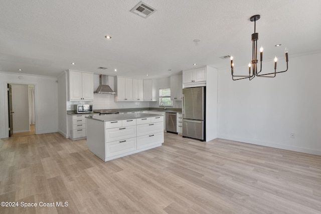 921 S Orlando Ave, Cocoa Beach, FL 32931 - kitchen with appliances with stainless steel finishes, wall chimney exhaust hood, light wood-type flooring, a chandelier, and recessed lighting