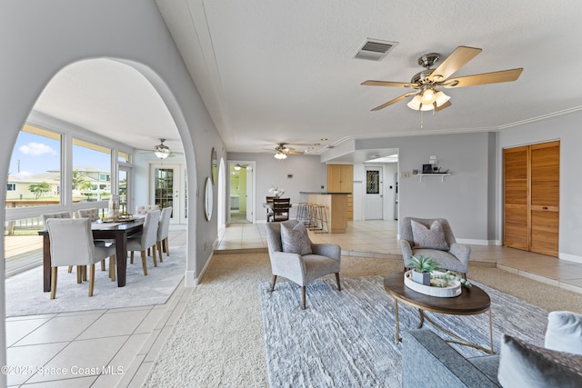 1700 Neptune Dr, Merritt Island, FL 32952 - living area featuring ceiling fan, light tile patterned flooring, a textured ceiling, arched walkways, and baseboards