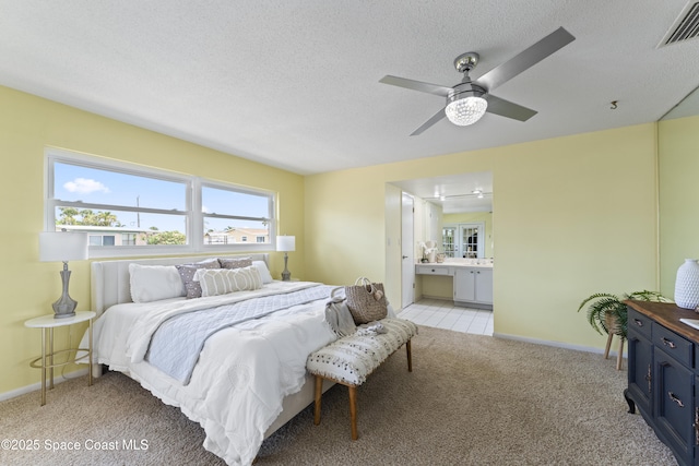 1700 Neptune Dr, Merritt Island, FL 32952 - bedroom with light colored carpet, ensuite bath, baseboards, a textured ceiling, and ceiling fan