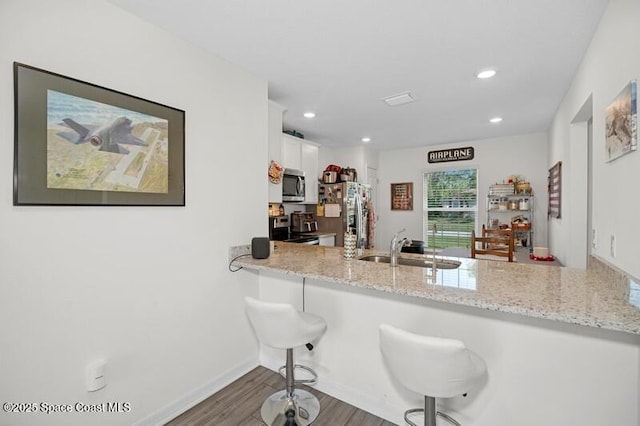 966 Stage St SE, Palm Bay, FL 32909 - kitchen with stainless steel appliances, a sink, white cabinets, a peninsula, and recessed lighting