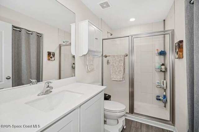 966 Stage St SE, Palm Bay, FL 32909 - bathroom with a shower stall, wood finished floors, toilet, and vanity
