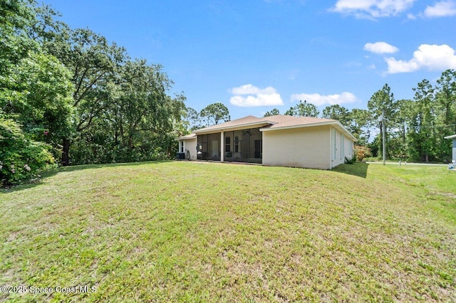 471 Hallmark St SE, Palm Bay, FL 32909 - rear view of house featuring a sunroom, a yard, ceiling fan, and stucco siding