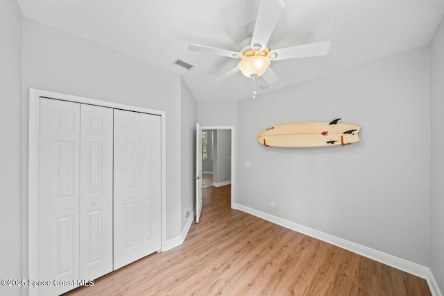 471 Hallmark St SE, Palm Bay, FL 32909 - unfurnished bedroom with baseboards, wood finished floors, a closet, and ceiling fan