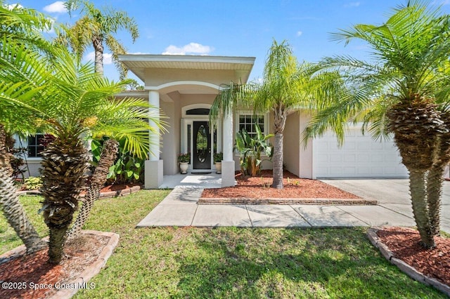 471 Hallmark St SE, Palm Bay, FL 32909 - property entrance with stucco siding, concrete driveway, and a garage
