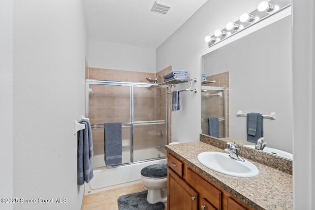 471 Hallmark St SE, Palm Bay, FL 32909 - bathroom featuring tile patterned flooring, vanity, bath / shower combo with glass door, a textured ceiling, and toilet