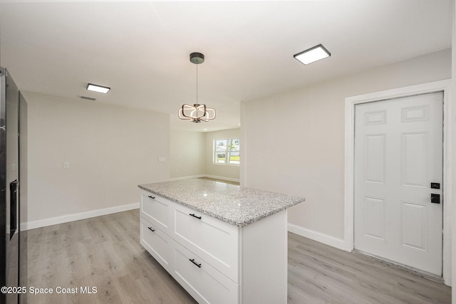 118 1st St, Merritt Island, FL 32953 - kitchen with light wood finished floors, white cabinets, pendant lighting, and a kitchen island