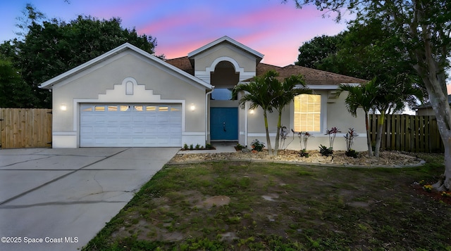 1451 Grand Cayman Dr, Merritt Island, FL 32952 - view of front of house featuring stucco siding, concrete driveway, a garage, and fence