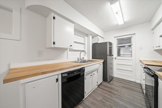 kitchen featuring black appliances, a sink, butcher block counters, wood finished floors, and white cabinets