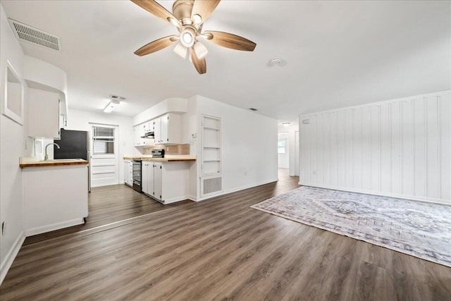 unfurnished living room with dark wood finished floors, a ceiling fan, baseboards, and a sink