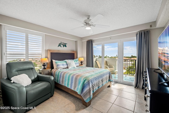 bedroom featuring access to outside, light tile patterned floors, a textured ceiling, and a ceiling fan