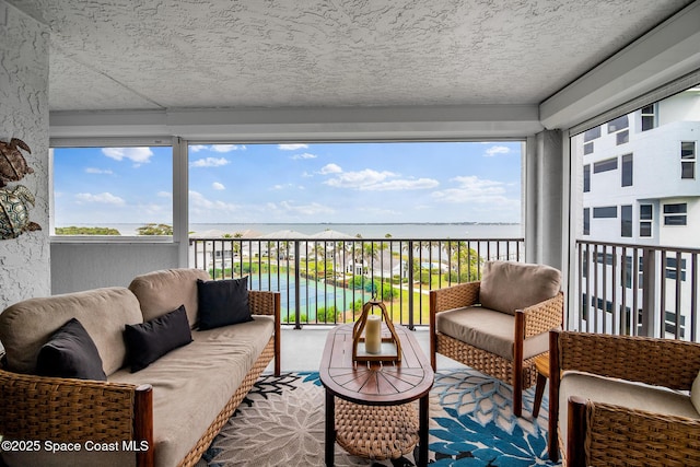 balcony featuring a water view and an outdoor living space