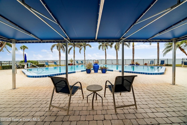 community pool with fence and a patio area