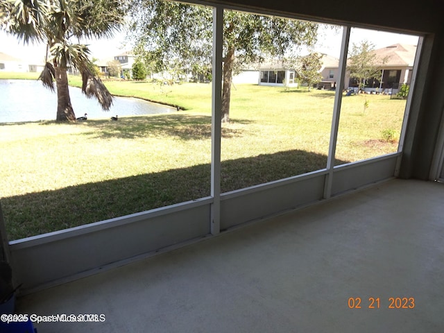 unfurnished sunroom featuring a water view