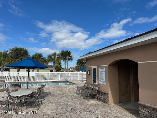 view of patio with fence and a community pool