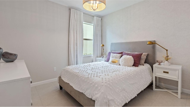 bedroom with light tile patterned floors and baseboards